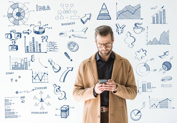 handsome developer in brown coat using smartphone, isolated on white with SEO and business icons