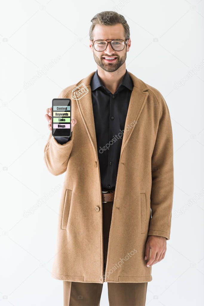 smiling developer presenting smartphone with SEO ideas, isolated on white
