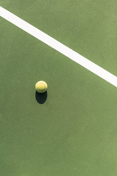 top view of tennis ball on green tennis court