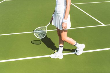 Tenis kortunda tenis raketi ile beyaz spor giyim Player'da kısmi görünümünü