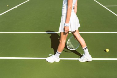 Tenis kortunda tenis raketi ile beyaz spor giyim Player'da kısmi görünümünü