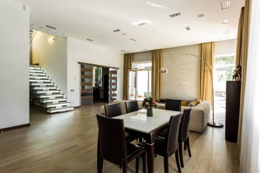 interior view of empty dining room with table, chairs and stairs clipart