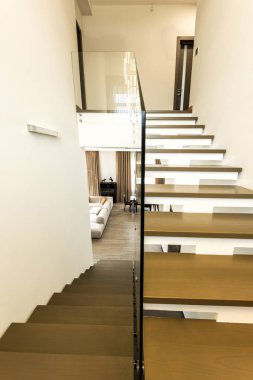 interior view of modern stairs with glass railings to living room clipart