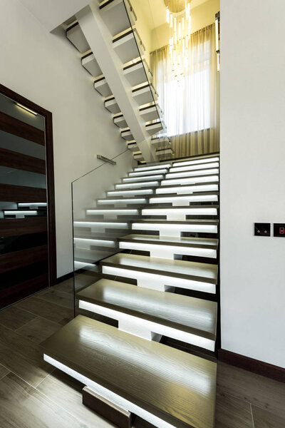 interior view of empty modern stairs with glass railings and door  