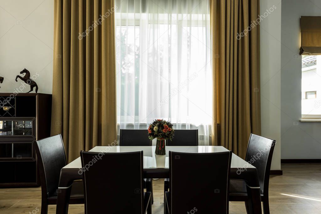 interior view of stylish dining room with table, chairs and big window