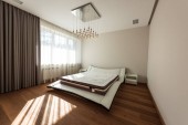 interiér moderní ložnice s postelí a žárovek na stropě