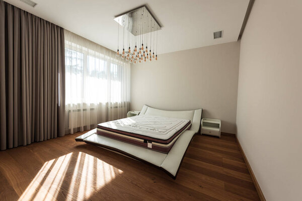 interior of modern bedroom with bed and light bulbs on ceiling