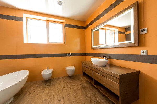 interior of modern bathroom in orange and white colors 