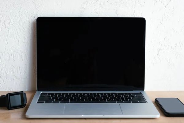 Laptop Mit Leerem Bildschirm Smartwatch Und Smartphone Auf Tisch — Stockfoto