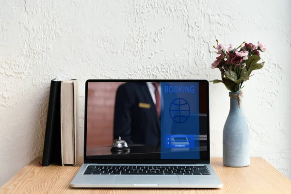 Laptop Mit Buchungswebseite Auf Dem Bildschirm Bücher Und Blumen Vase — kostenloses Stockfoto