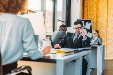 ofiste masalarında çalışan çok kültürlü iş adamları