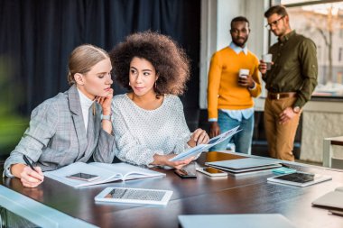 office belgelerinde bakarak çok kültürlü iş kadınları