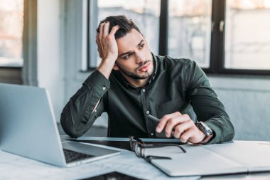 ofiste masada oturan ve uzak seyir yakışıklı işadamı