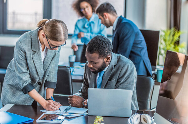 businesswoman writing something to notebook in office
