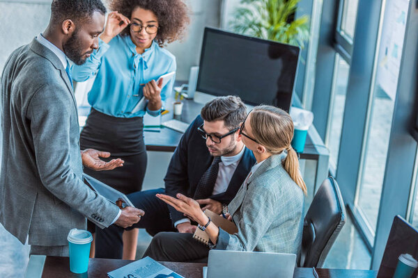 multicultural businesspeople having conversation in office