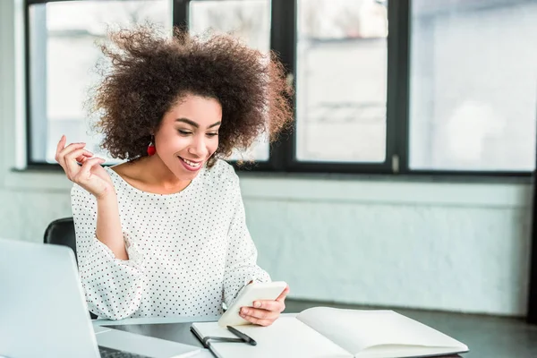 Uśmiechający Się African American Kobieta Przy Użyciu Smartfona Biurze — Zdjęcie stockowe