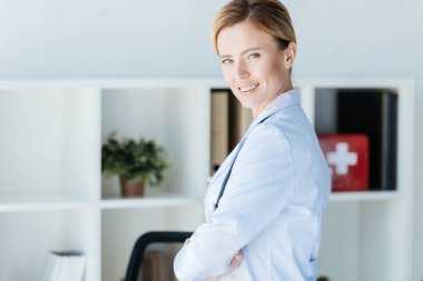 Beyaz önlük kamera Office bakarak yetişkin kadın doktor portresi 