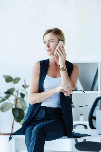 Confident Businesswoman Holding Eyeglasses Talking Smartphone Office — Free Stock Photo