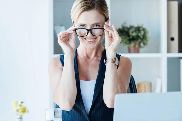 Smiling Adult Businesswoman Adjusting Eyeglasses Looking Camera Office — Stock Photo, Image