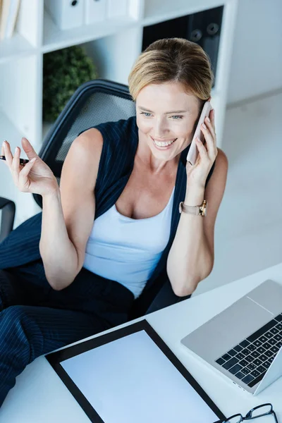 High Angle View Smiling Businesswoman Talking Smartphone Table Laptop Clipboard — Free Stock Photo