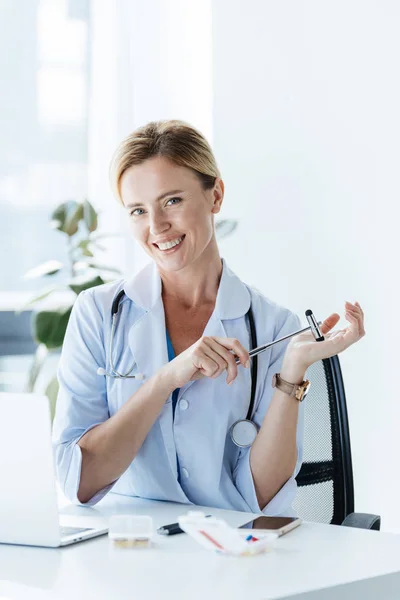 Feliz Médico Femenino Con Estetoscopio Martillo Reflejo Mesa Consultorio —  Fotos de Stock