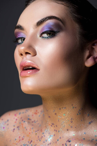 sensual glamorous girl posing with glitter on body, isolated on grey