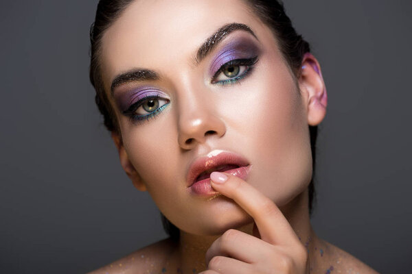 sensual thoughtful woman with glitter makeup, isolated on grey