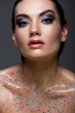 çekici göz alıcı model ile poz parıldıyor ve gri izole çıplak vücut üzerinde parıldayan