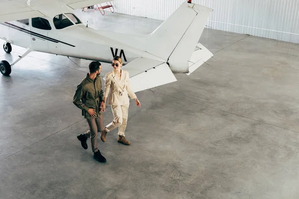 High Angle View Young Couple Stylish Jackets Walking Hangar Airplane — Stock Photo, Image