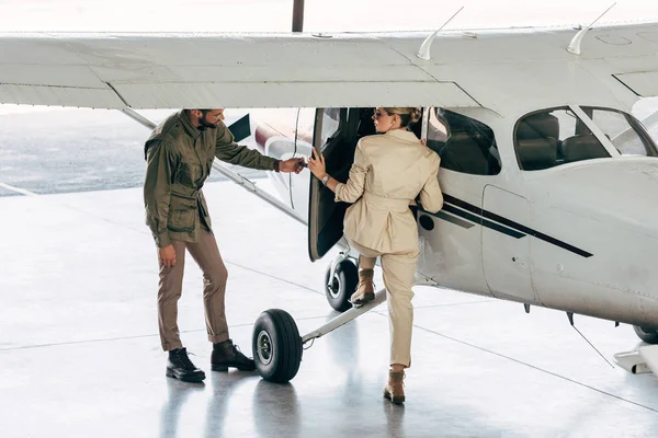 Stylish Young Man Opening Door Girlfriend While She Boarding Plane — Stock Photo, Image