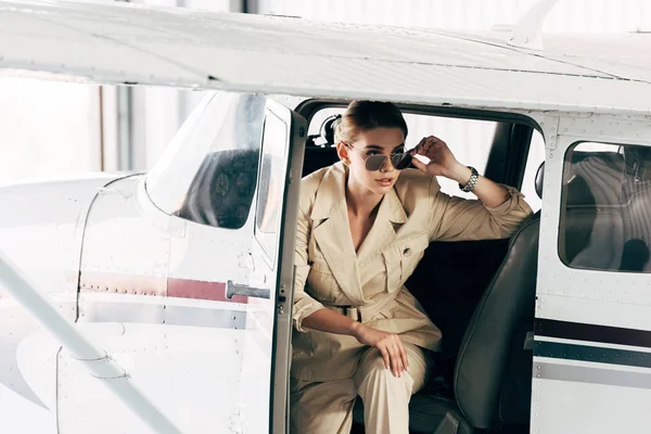 Young Woman Sunglasses Jacket Sitting Looking Away Airplane — Free Stock Photo