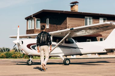 Dikiz şık erkek pilot uçak yürüyüş deri ceketli