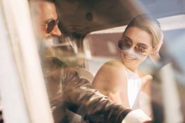 güneş gözlüğü ve deri ceket kız uçağın kabinde oturan mutlu erkek pilot seçici odak 
