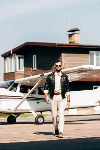 Kendine Güvenen Şık Erkek Pilot Deri Ceket Uçak Yürüyüş Güneş — Stok fotoğraf