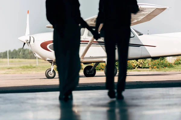 Imagem Cortada Silhuetas Jovem Casal Mãos Dadas Caminhando Para Avião — Fotografia de Stock