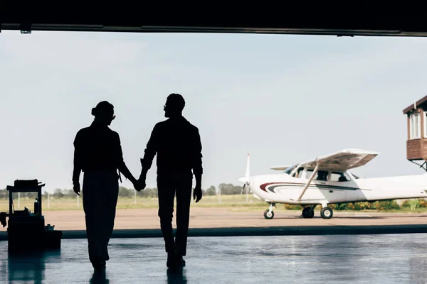 Rear View Silhouettes Young Couple Holding Hands Walking Hangar Airplane — Stock Photo, Image