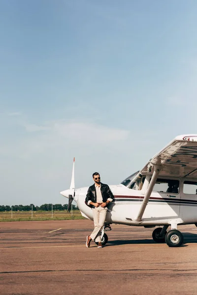 Modny Mężczyzna Pilot Skórzanej Kurtce Okulary Przeciwsłoneczne Pozowanie Pobliżu Płaszczyzny — Zdjęcie stockowe