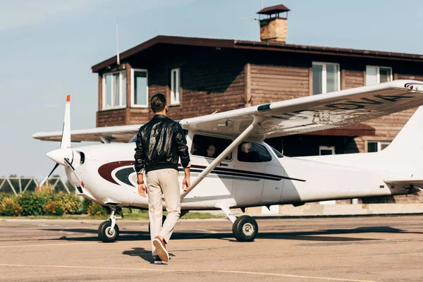 Visão Traseira Piloto Masculino Elegante Jaqueta Couro Andando Perto Avião — Fotografia de Stock