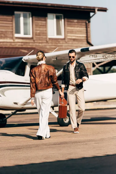 Stylish Woman Leather Jacket Giving Vintage Suitcase Boyfriend Airplane — Stock Photo, Image