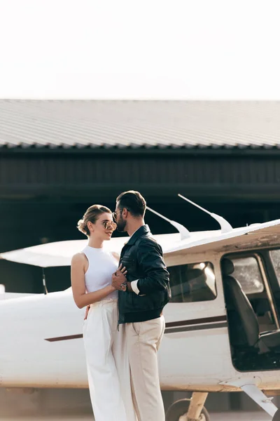 Young Stylish Couple Sunglasses Embracing Standing Face Face Airplane — Stock Photo, Image