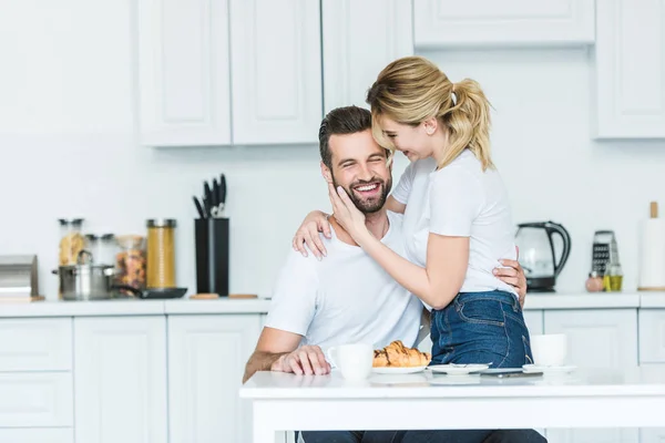 Atractiva Chica Sonriente Abrazando Novio Feliz Mientras Desayunan Juntos —  Fotos de Stock