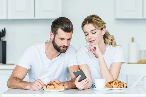 Jeune Couple Utilisant Smartphone Tout Prenant Petit Déjeuner Ensemble — Photo