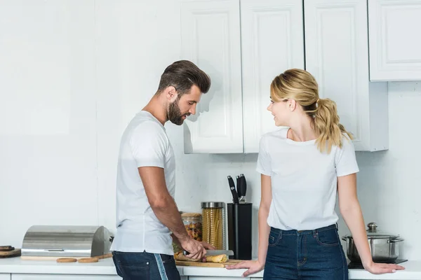 Schöne Junge Frau Schaut Freund Beim Baguetteschneiden Küche — Stockfoto