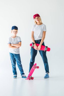 Anne ve oğlu rahat kıyafetler ve paten üzerinde beyaz ile ayakta kapaklar