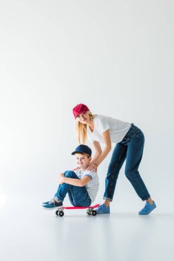 kırmızı şapkalı beyaz skate haritasında oğlu iterek mutlu anne