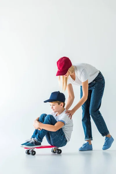 모자에 화이트 스케이트에 아들을 어머니의 — 무료 스톡 포토