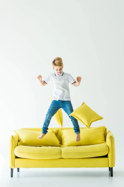 Menino Adorável Pulando Sofá Amarelo Branco — Fotografia de Stock