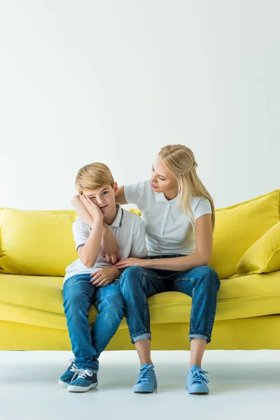 Mãe Abraçando Filho Chateado Sofá Amarelo Branco — Fotografia de Stock