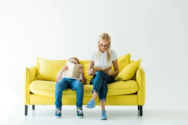 Attractive Mother Adorable Son Reading Books Yellow Sofa White — Stock Photo, Image