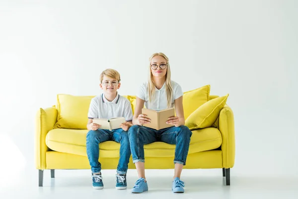 Smiling Mother Son Glasses Holding Books Looking Camera Yellow Sofa — Stock Photo, Image